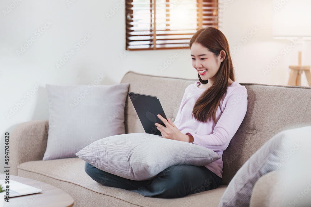 Attractive Asian woman resting comfortable living room and using digital tablet, Relax, Sofa, Lifestyle Attractive Asian woman resting comfortable living room and using digital tablet, Relax, Sofa, Lifestyle