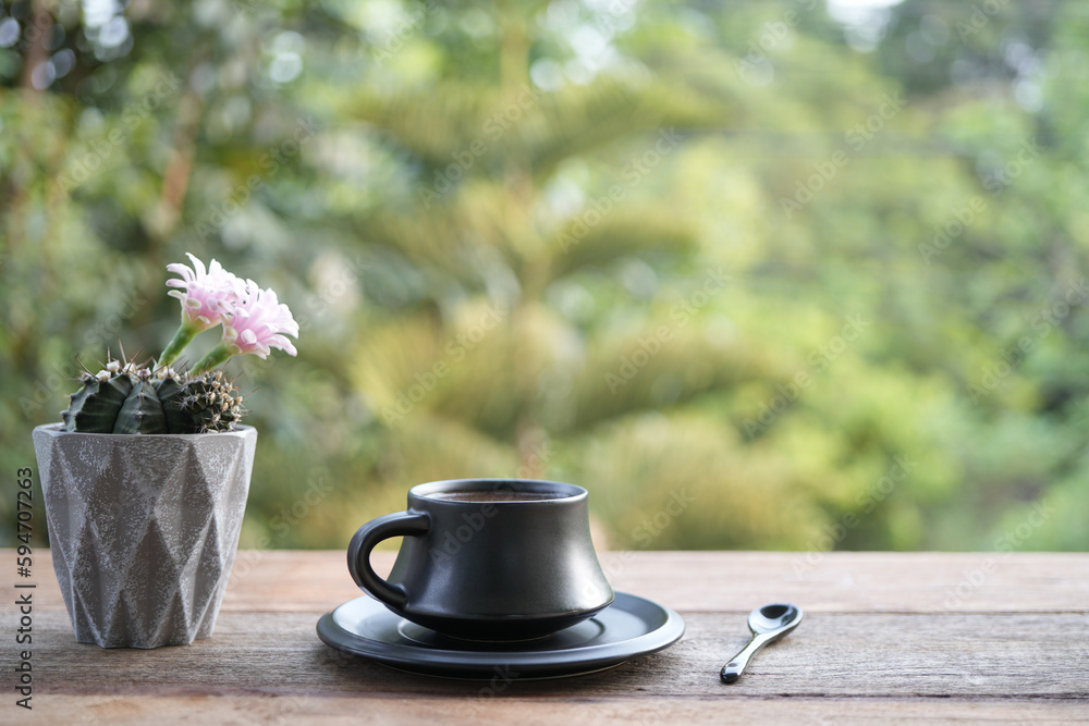 Earthenware tea cup and pink cactus flower on wooden table Earthenware tea cup and pink cactus flower on wooden table
