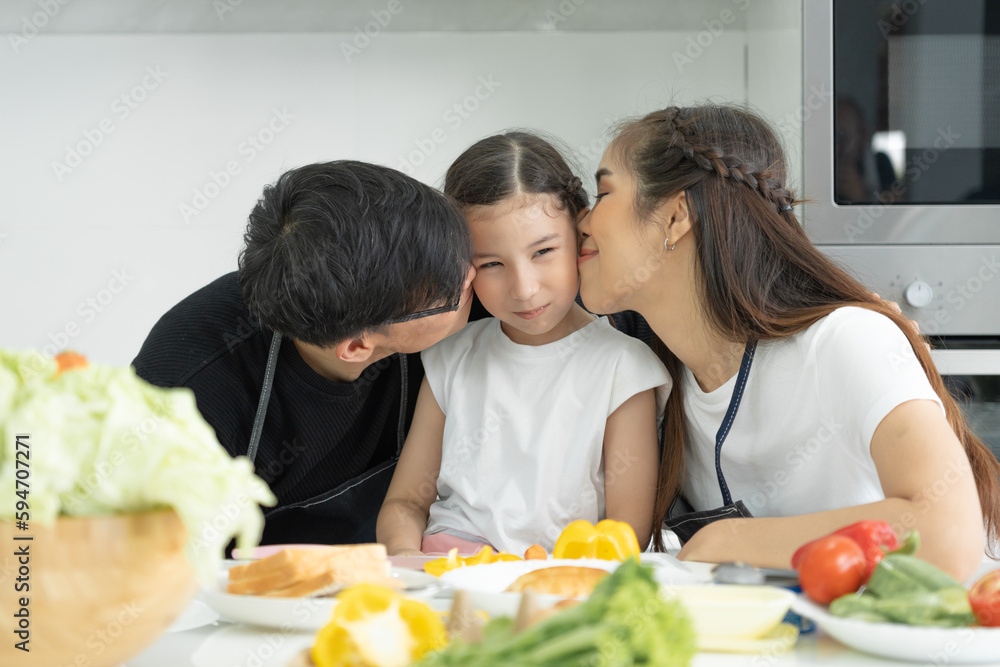 family activities together during the holidays. Father and mother kissing daughter , Parents and children are having activity on vacant time. weekend, enjoyment, happy, togetherness, feel good.