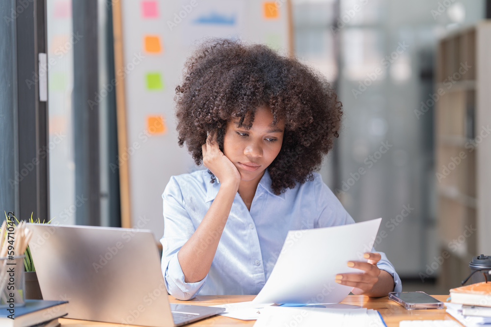Female Entrepreneur. Cheerful African American Businesswoman Working On document and Laptop In Modern Office. Empty Space Female Entrepreneur. Cheerful African American Businesswoman Working On document and Laptop In Modern Office. Empty Space