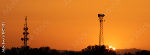 Panorama of sunset behind two communication towers  photo