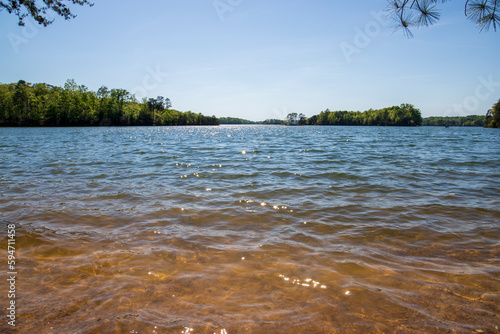 a gorgeous spring landscape at Lanier Point Park with rippling blue water surrounded by lush green trees and plants with powerful cloud at sunset at Lake Lanier in Gainesville Georgia USA photo