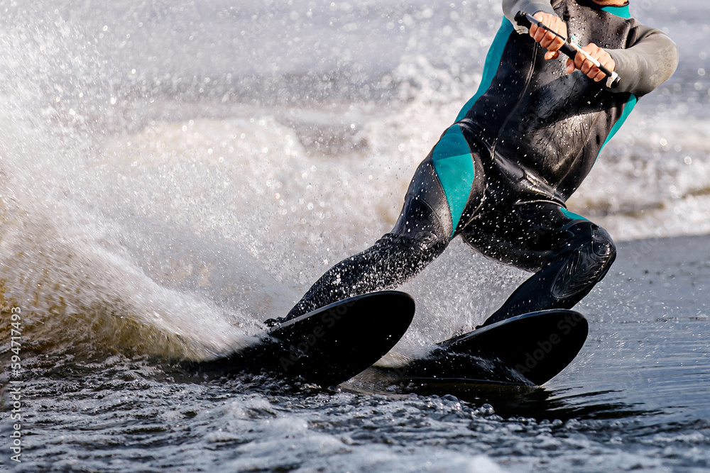 Naklejka premium close-up man athlete riding waterskiing on lake, extreme summer water sports