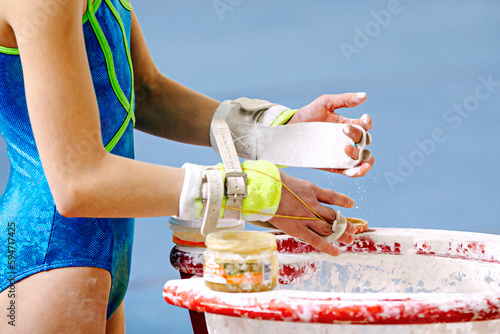 Canvas Print close-up hands girl gymnast in gymnastics grips apply gym chalk from magnesia st