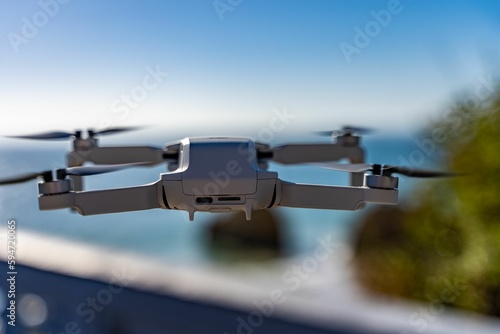 Close-up shot of a small Camera drone on a mid-flight on a blurred background