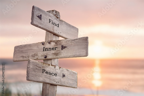  find inner peace text quote written on wooden signpost at the beach during sunset.