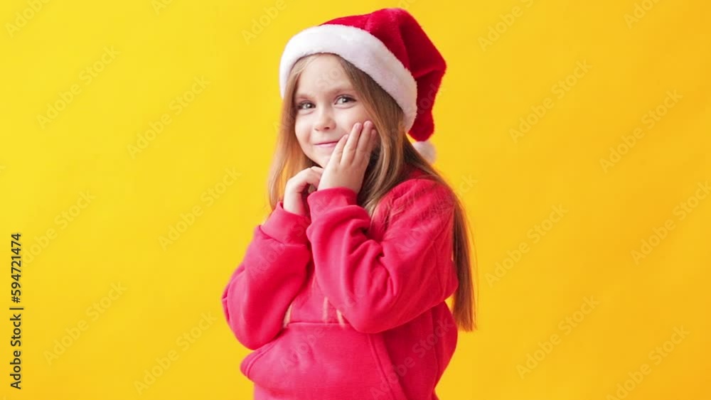 portrait of a little girl in a santa hat on a yellow background portrait of a little girl in a santa hat on a yellow background