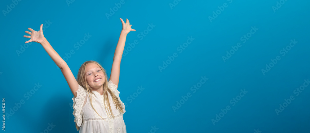 Happy childhood. A smiling young girl raises her hands to the top. isolated. Background blue. banner. copy space