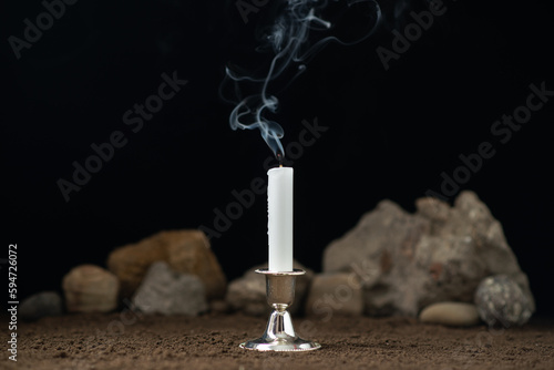 fireless candle with rocks around on a dark background death sci fi photo