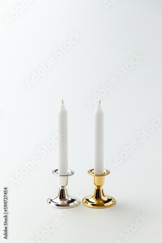 white candles inside elegant candlesticks on white background flame lamp fire steel metallic