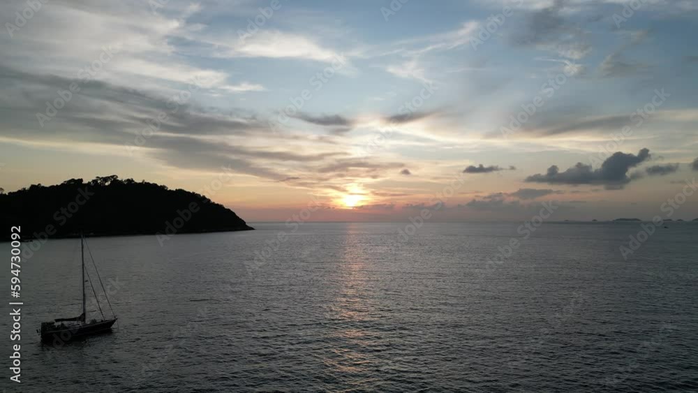 Golden sunset shining over the calm sea with canoes and the Koh Lipe island in Thailand Golden sunset shining over the calm sea with canoes and the Koh Lipe island in Thailand