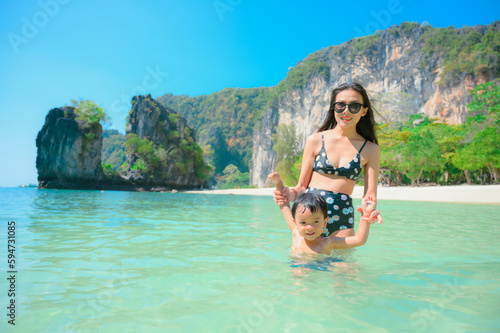 Happy mother and son resting at beach in summer, Krabi, Thailand