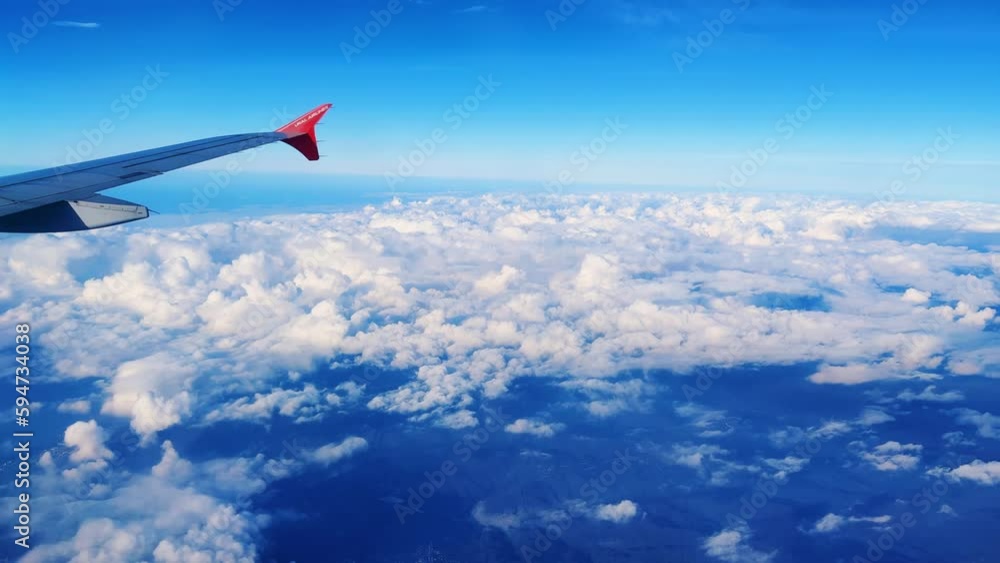 Flying by plane. The wing of an airplane flying above the clouds. View from the plane window. Travel by air. 4K video. Sochi, Russia 2023 Flying by plane. The wing of an airplane flying above the clouds. View from the plane window. Travel by air. 4K video. Sochi, Russia 2023