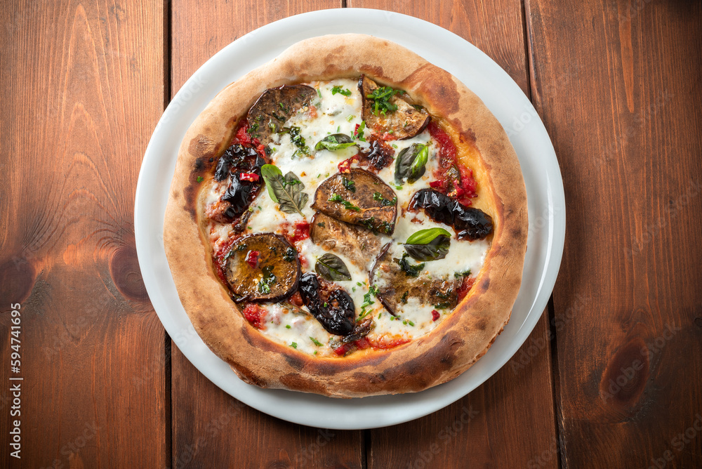 Pizza vegetariana condita con sugo, mozzerella e melanzane, cibo italiano Pizza vegetariana condita con sugo, mozzerella e melanzane, cibo italiano