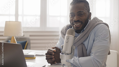 Fotografie An African American man live streamer commenting on sports or cyber games and br