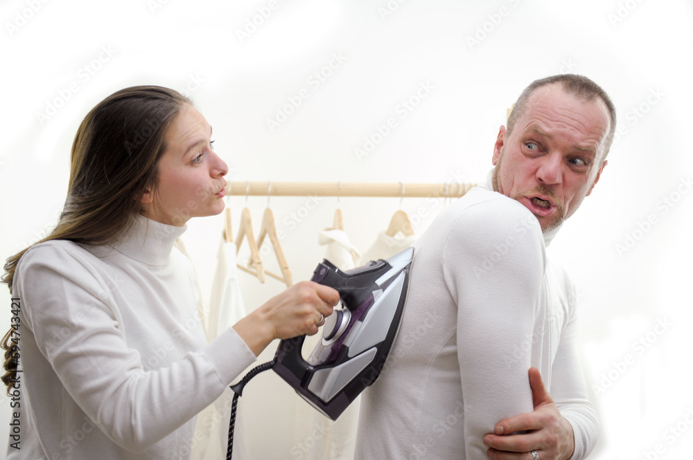 Obraz premium Female hand ironing clothes top view isolated on white background. Young woman with iron ironing man's shirt seen from above during housework. 