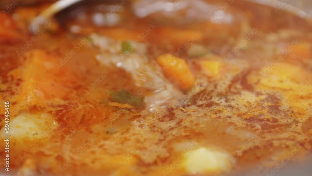 Hungarian goulash soup cooking close-up in pot, chef cook traditional polish or zech soup in restaurant. Hungarian goulash soup cooking close-up in pot, chef cook traditional polish or zech soup in restaurant.