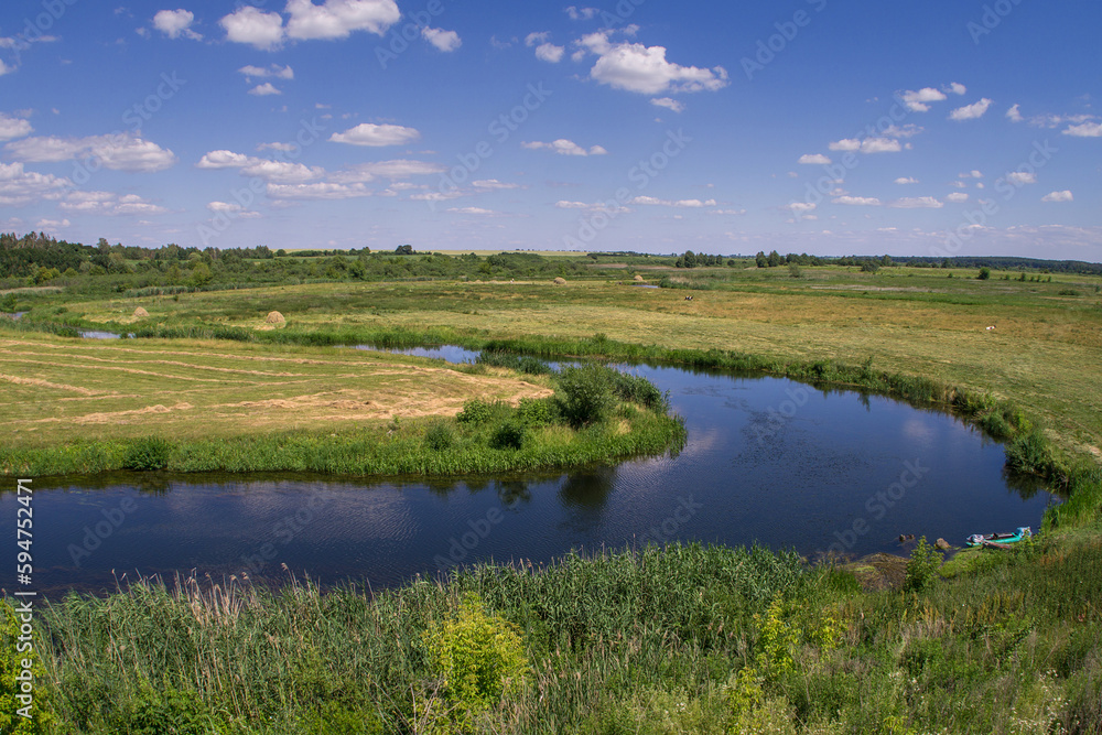 Summer landscape of a river floodplain with a winding channel.
