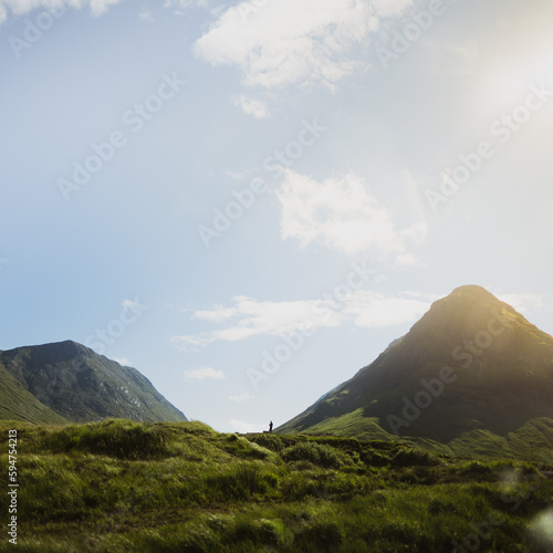 Panoramische Aussicht auf Schottlands Hügel und Berge mit Wanderer in Silhouette
