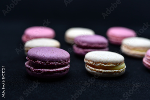 Multicolored cookies on a black background. Macaroni cookies close-up.Delicious and sweet cookies.