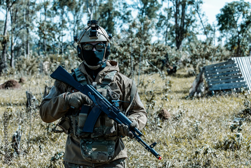 Anonymous soldier with AK-47 in the middle of the battlefield