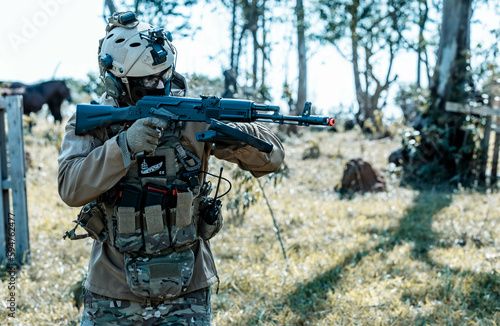 Anonymous soldier with AK-47 in the middle of the battlefield