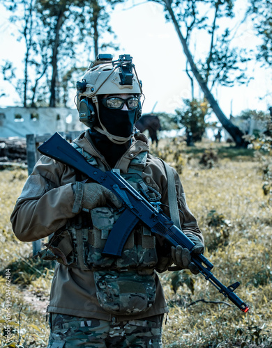 Anonymous soldier with AK-47 in the middle of the battlefield