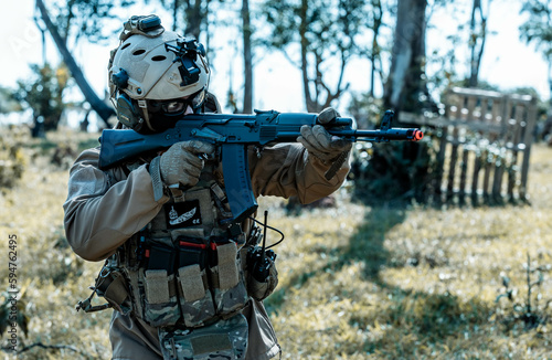 Anonymous soldier with AK-47 in the middle of the battlefield