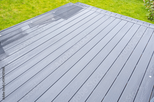 Ash grey composite decking on a rainy wet day showing the full grain of the decking boards A good background image