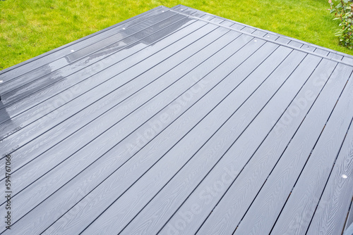 Ash grey composite decking on a rainy wet day showing the full grain of the decking boards A good background image