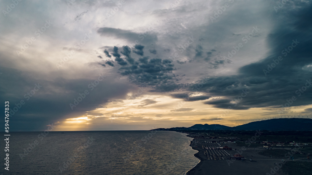 Fototapeta premium Aerial view of a sunset over the sandy beach ad sea coast