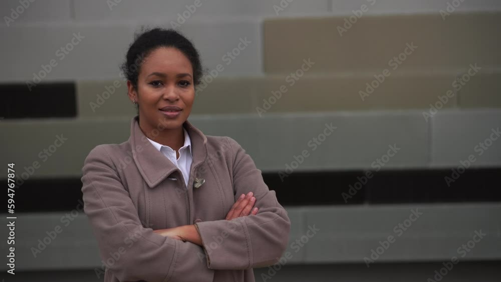 Portrait of smiling young african american woman with arms crossed on chest outside Portrait of smiling young african american woman with arms crossed on chest outside