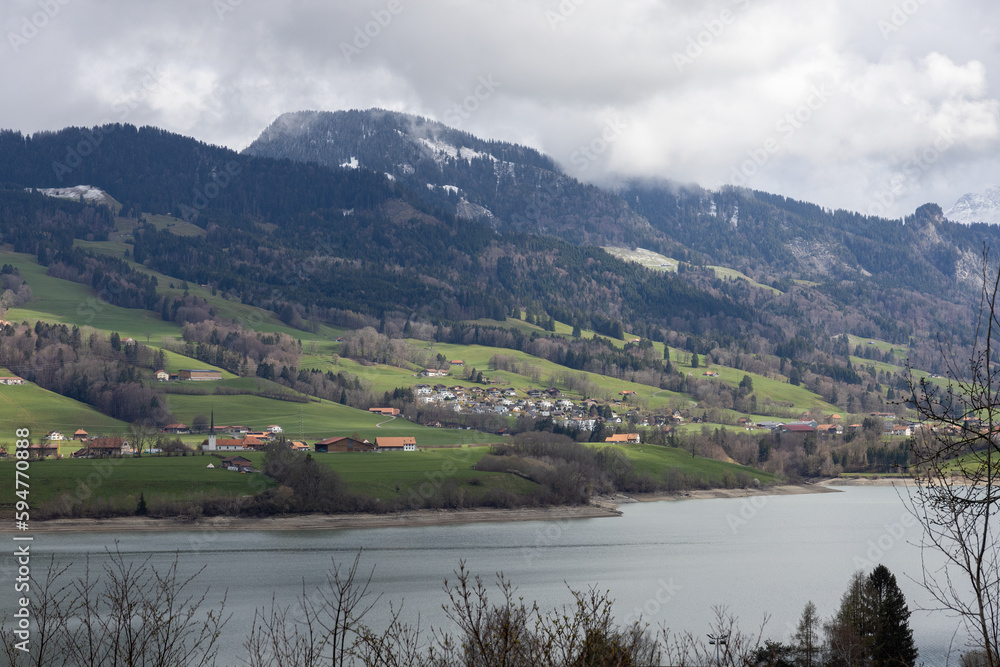 picture of a mountainous landscape in Switzerland covered with snow and partly in the clouds with Greyerzersee