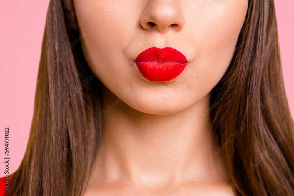 Close up half face portrait of young woman with red lips sand a kiss isolated on bright yellow background Close up half face portrait of young woman with red lips sand a kiss isolated on bright yellow background
