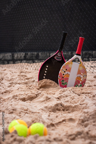 Women's and children's beach tennis rackets on the sand. Beach Tennis Kids. Family beach tennis. Mother and daughter at beach tennis. Copy space