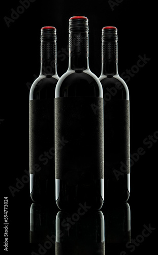 Three silhouetted and outlined bottles of red wine on the black background 