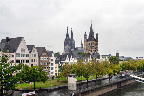 Church of St. Martin in night, recreational ship on riverbank of Rhine and reflections in water. Famous Cologne cathedral