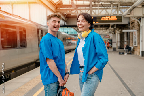 Beautiful couple at railway station waiting for the train. Woman and man running to board a train