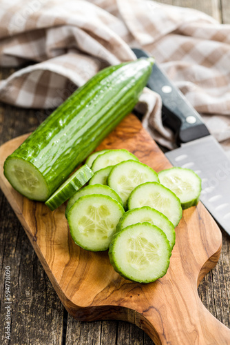 Sliced fresh green cucumber on cutting board. photo