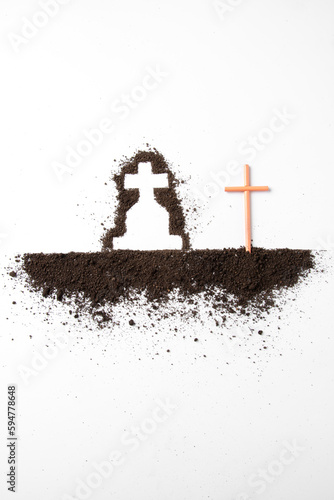 top view of cross shape with dark soil on white desk grim reaper death funeral