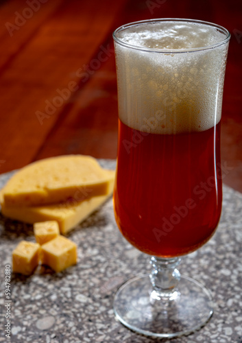 Glass of Belgian light blond beer made in abbey and tasty belgian cheese photo