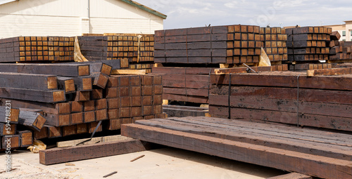stacked piles of new railroad ties also called railway sleepers with anti-split plates on the ends