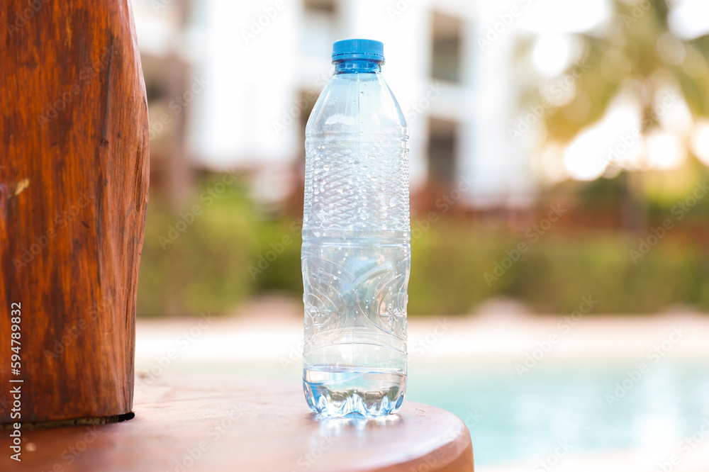 plastic bottles scattered around the pool and beach represent the