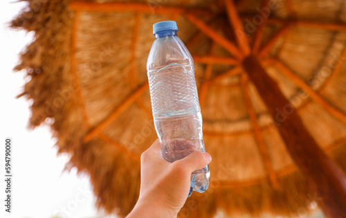 plastic bottles scattered around the pool and beach represent the negative impact of human activity on the environment. The pollution caused by single-use plastic bottles affects the ocean