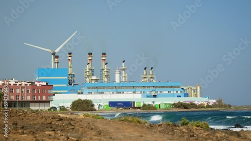 Panorama of the coastline with a plant and a wind turbine.