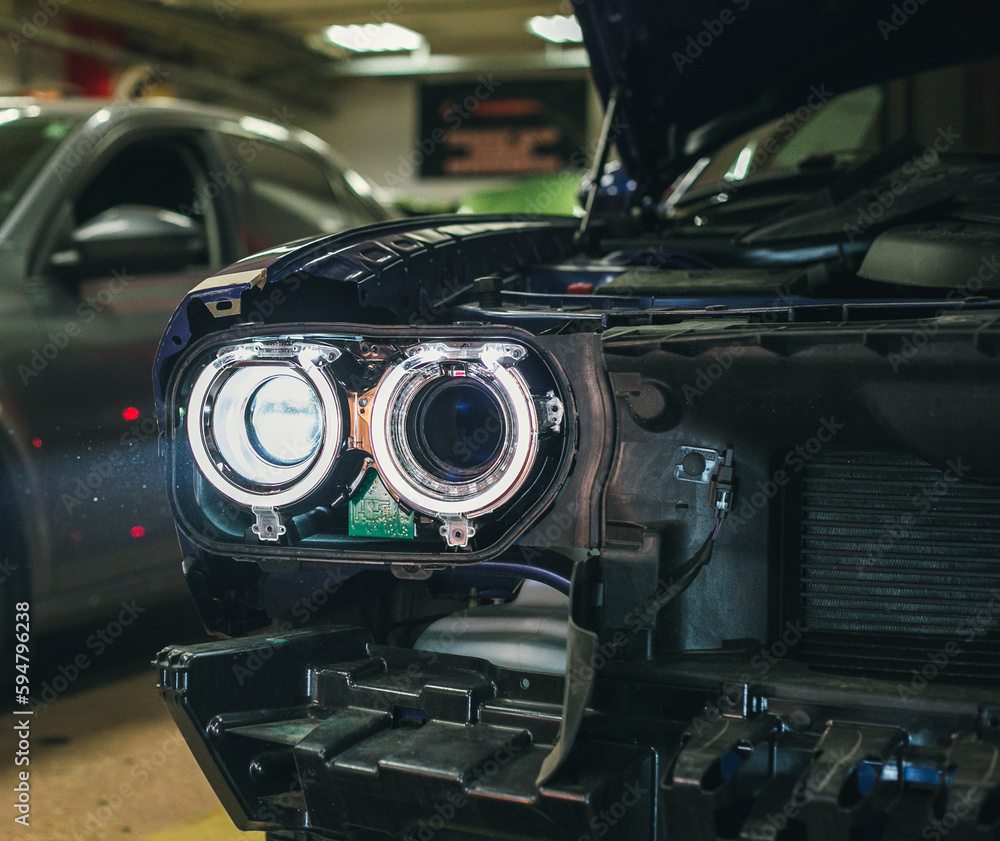 Foto de Car headlight in repair closeup. The car mechanic installs the