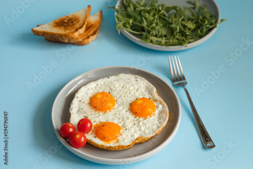 Fried eggs in a plate on a blue background