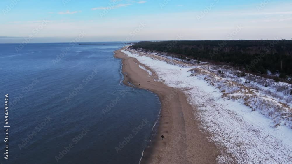 Winter in cold Baltic sea snowy beach in Gdansk. Aerial view of snow covered beach and dunes dark calm sea waves nature landscape captured with drone. Winter tourism in Poland Winter in cold Baltic sea snowy beach in Gdansk. Aerial view of snow covered beach and dunes dark calm sea waves nature landscape captured with drone. Winter tourism in Poland