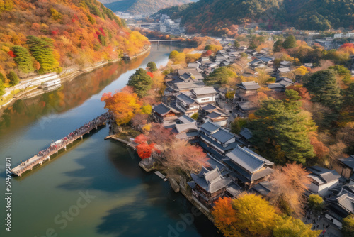 Arashiyama in autumn season along the river in Kyoto, Japan, Aerial view Arashiyama Togetsu or Togetsukyo bridge ancient architecture and boats in Katsura river, Arashiyama, Kyoto, Japan, Asia