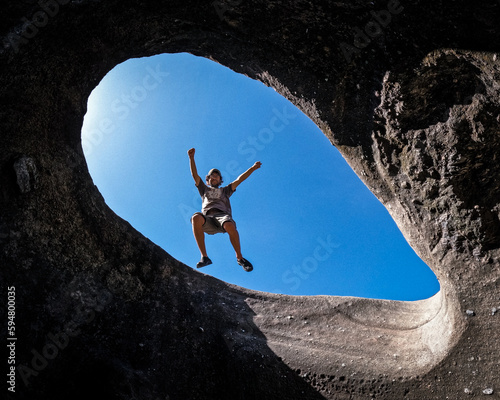 Pessoa pulando em buraco de formacao rochosa no Vale da Lua, em alto paraíso,  goiás, Chapada dos veadeiros  photo